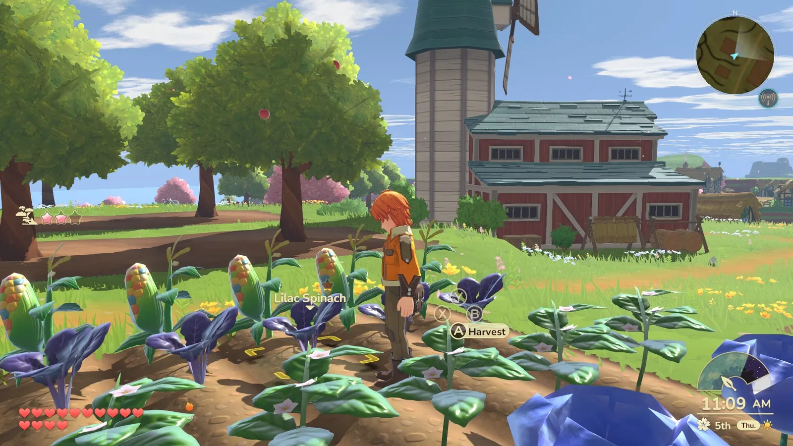 Harvesting a field of crops beside a barn and silo