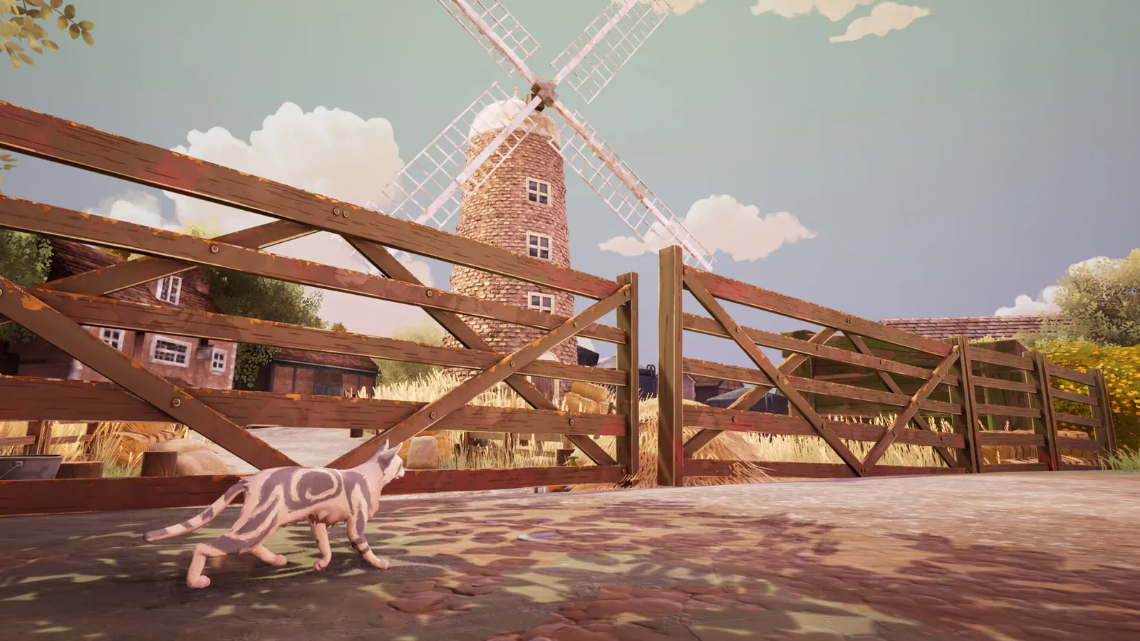 A patched cat crossing a farmyard by a wooden gate and a windmill